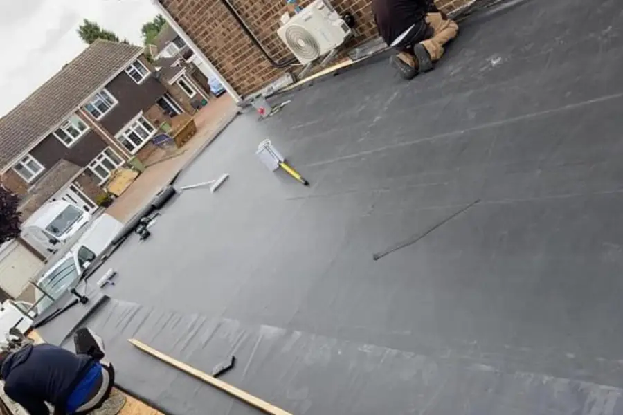 EPDM rubber membrane being laid on a flat roof
