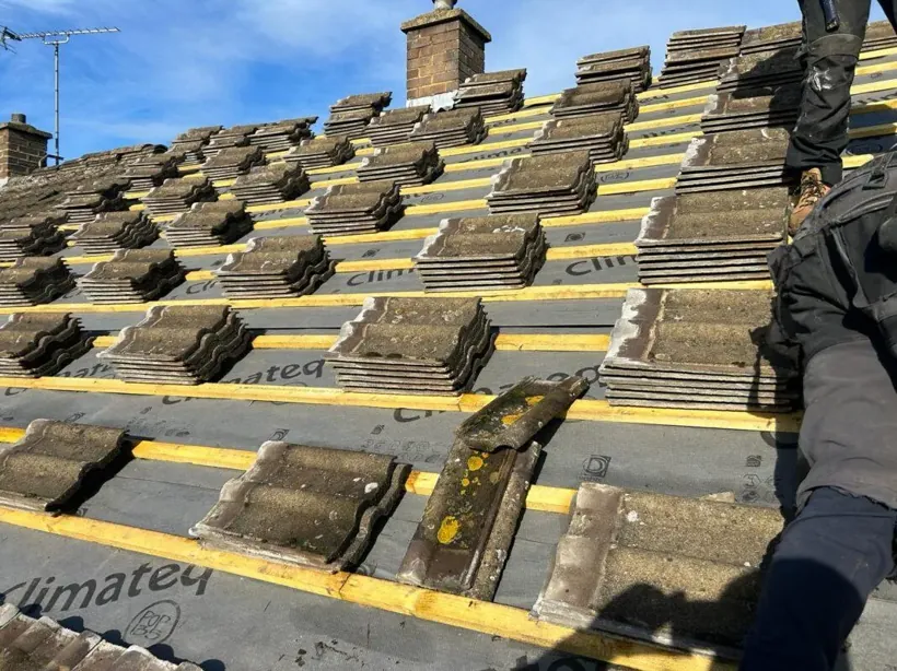 Roofers re-tiling a pitched roof in Northampton